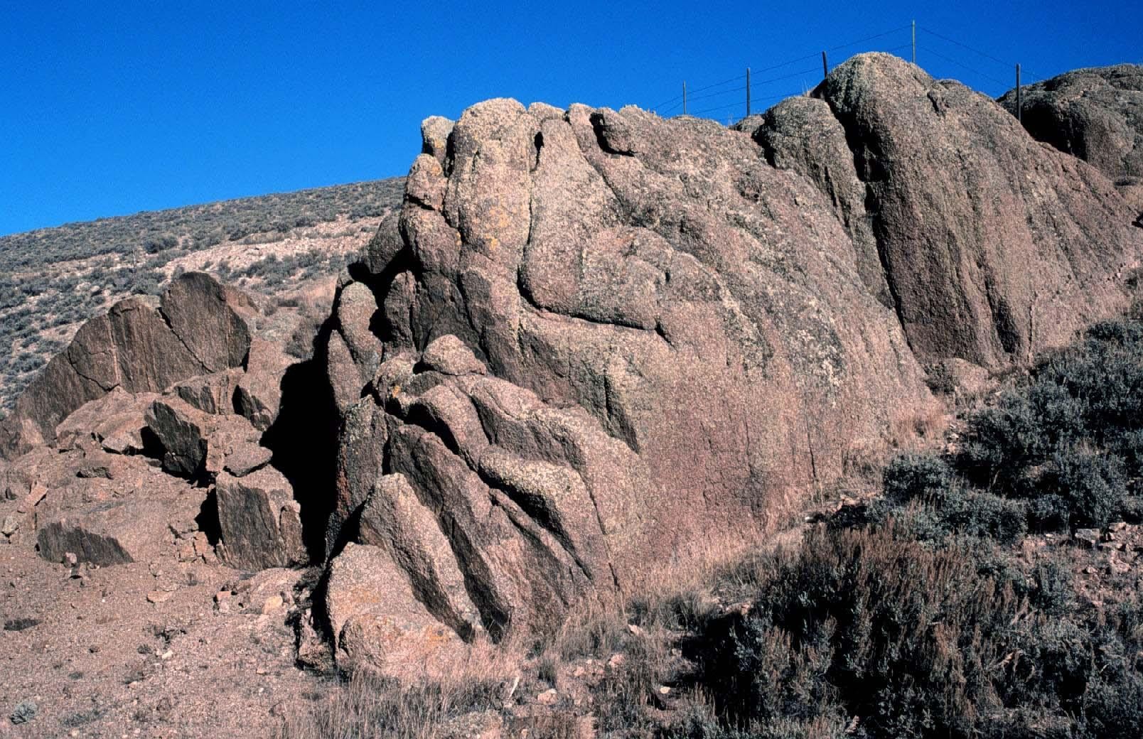 Weathered granite outcrop under a deep blue sky.