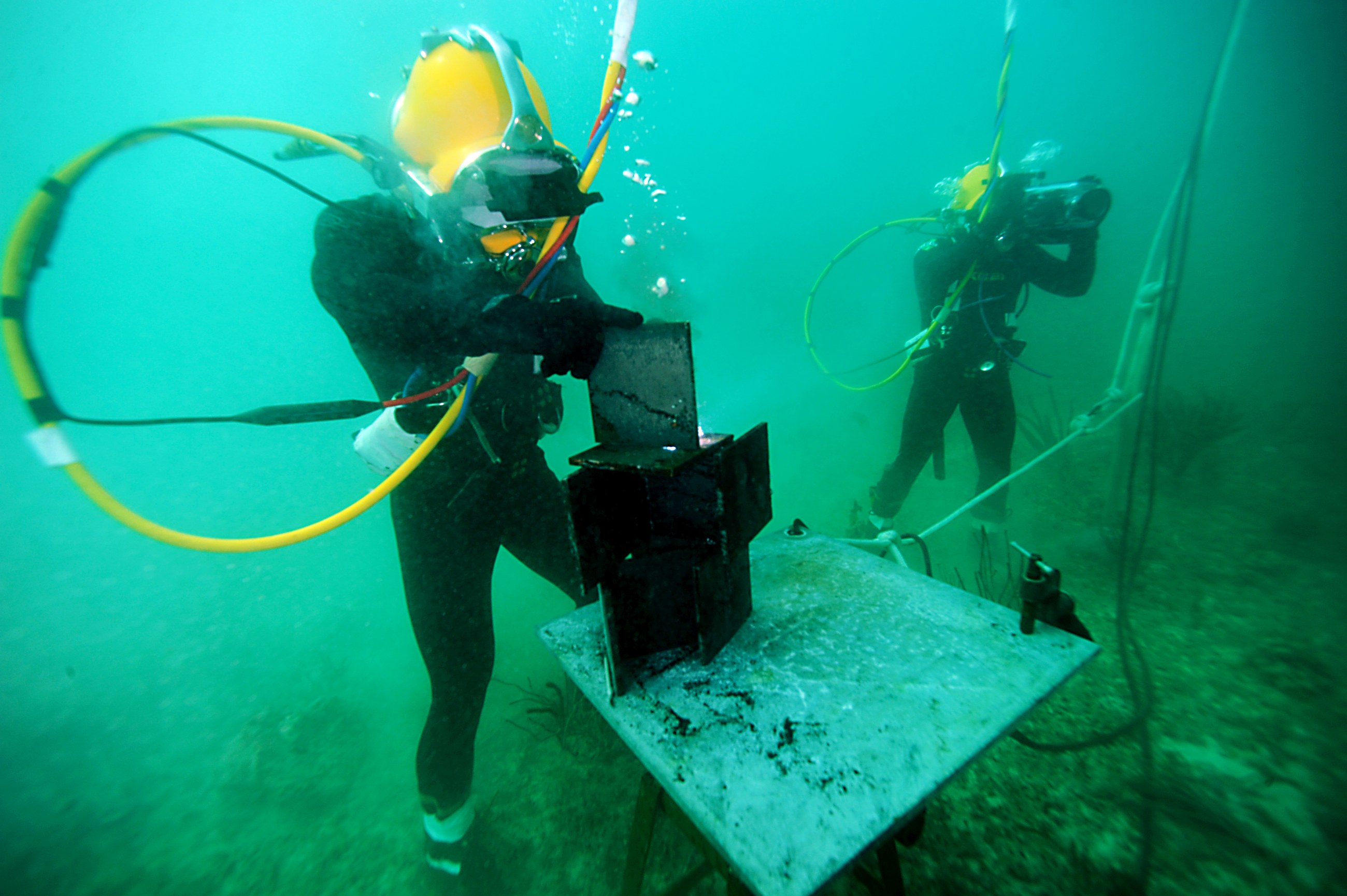 Professional diver performing underwater welding on a submerged structure